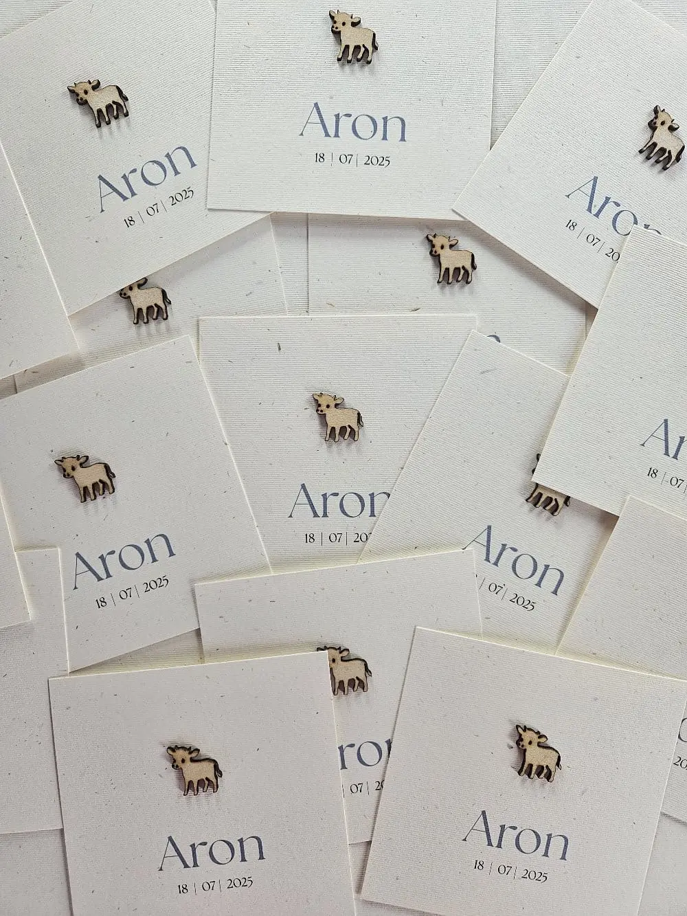 Vierkant geboortekaartje Aron op gerecycled papier met een houten koe